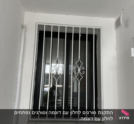 חלון עם סורגים לבנים ודוגמה דקורטיבית